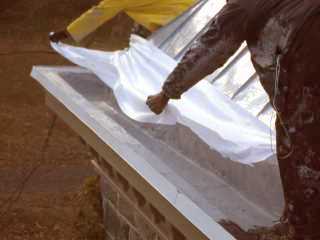 Roof Menders crew placing the mesh to contour the gutter profile